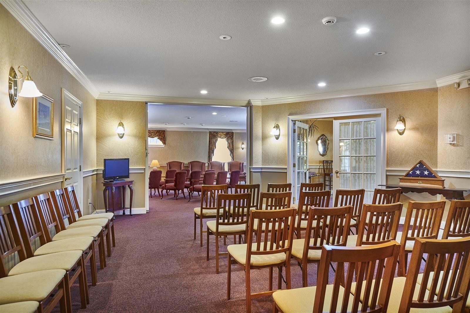 A room with rows of chairs and a piano in it.