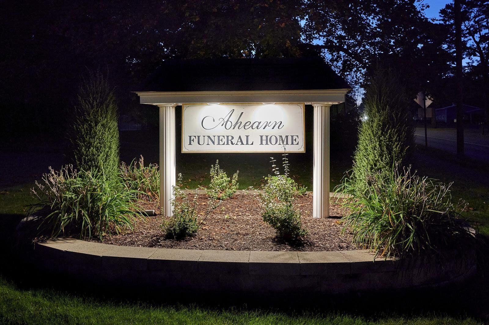 A sign for a funeral home is lit up at night