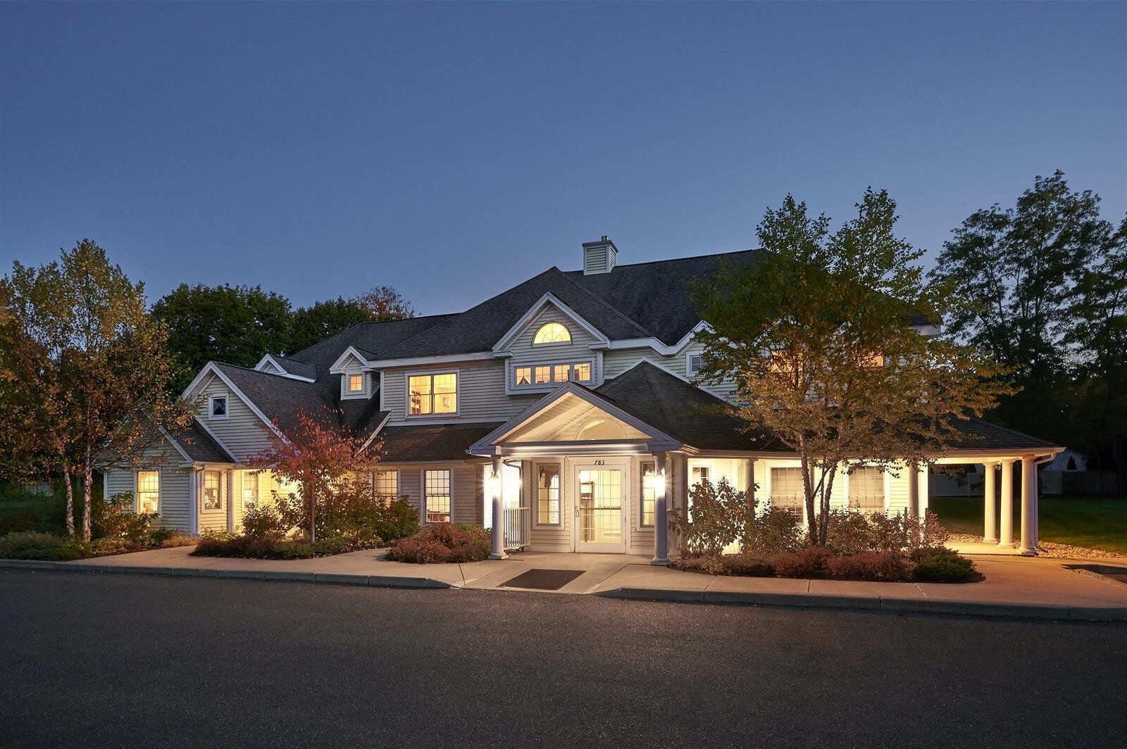 A large white house is lit up at night