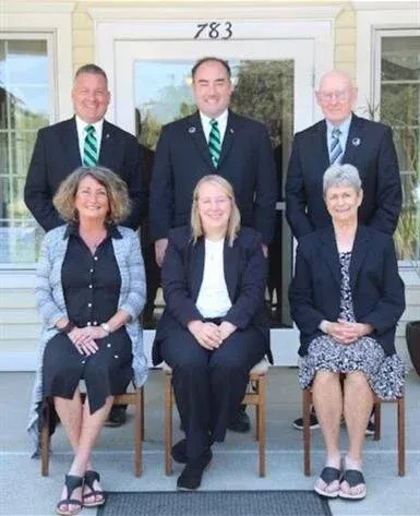 A group of people are posing for a picture in front of a building.