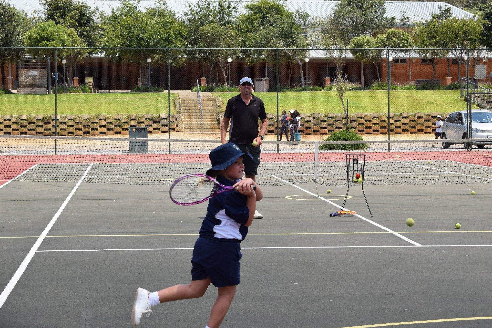 a young girl is swinging a tennis racket on a tennis court