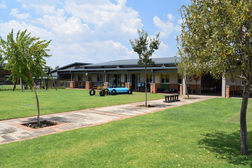 a large grassy field with a building in the background