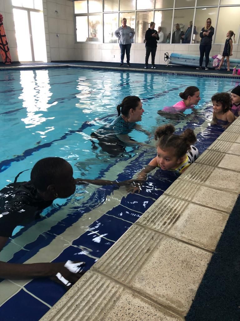 a group of people are swimming in a swimming pool .