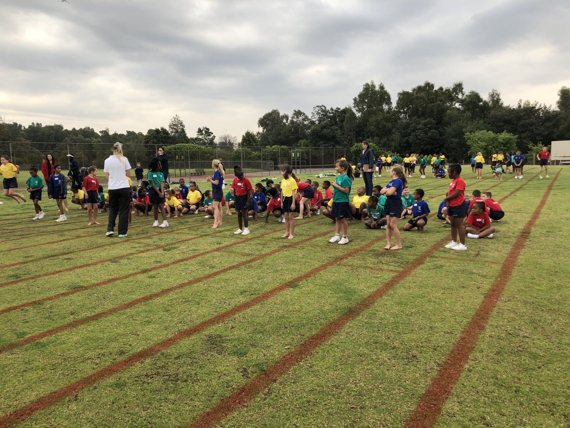 a group of children are sitting on the grass in a field .