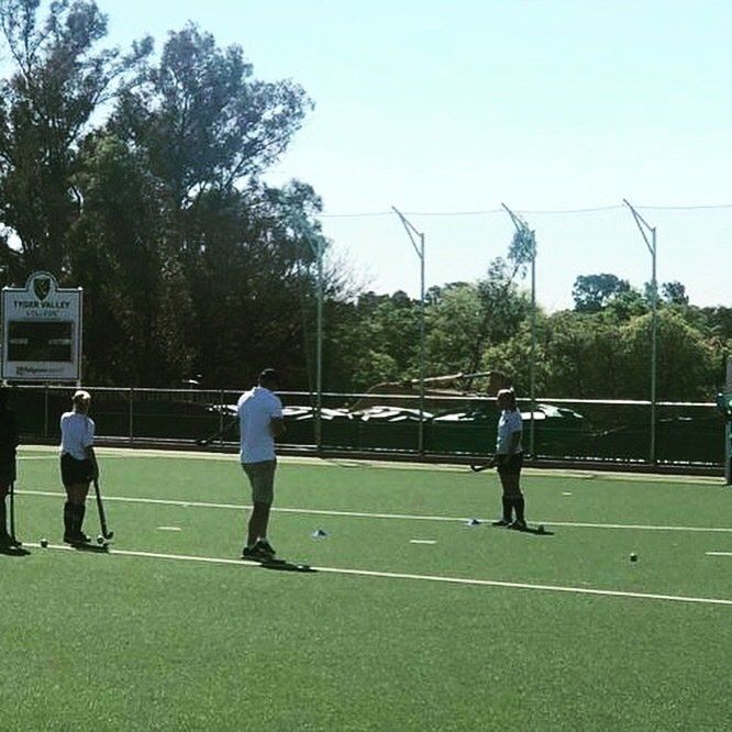 a group of people are playing a game of field hockey