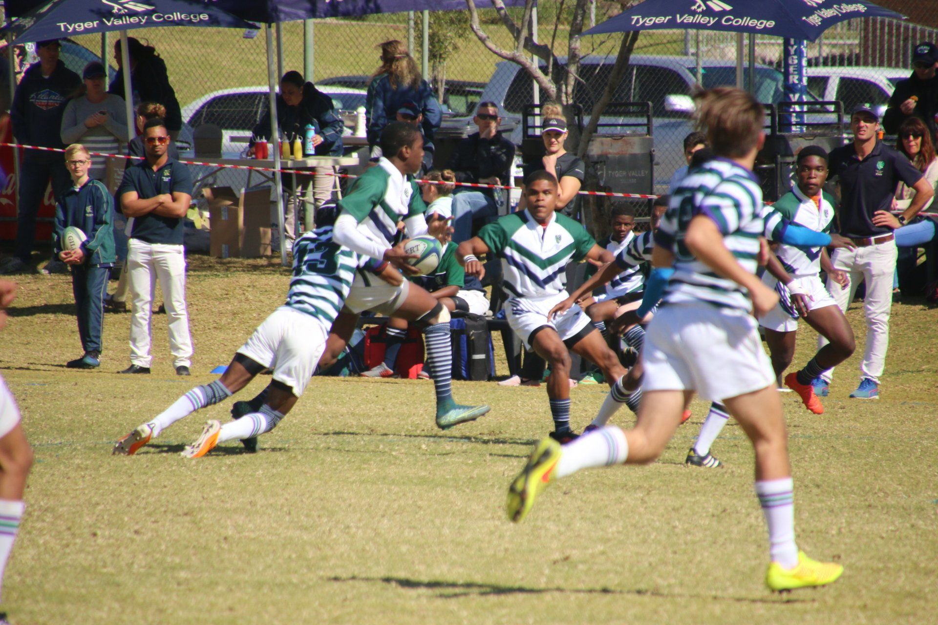 a group of young boys are playing a game of rugby on a field .