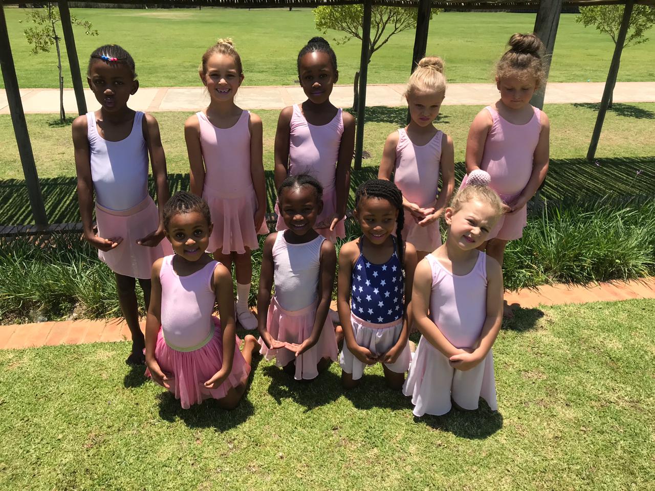 a group of young girls are posing for a picture in a park .