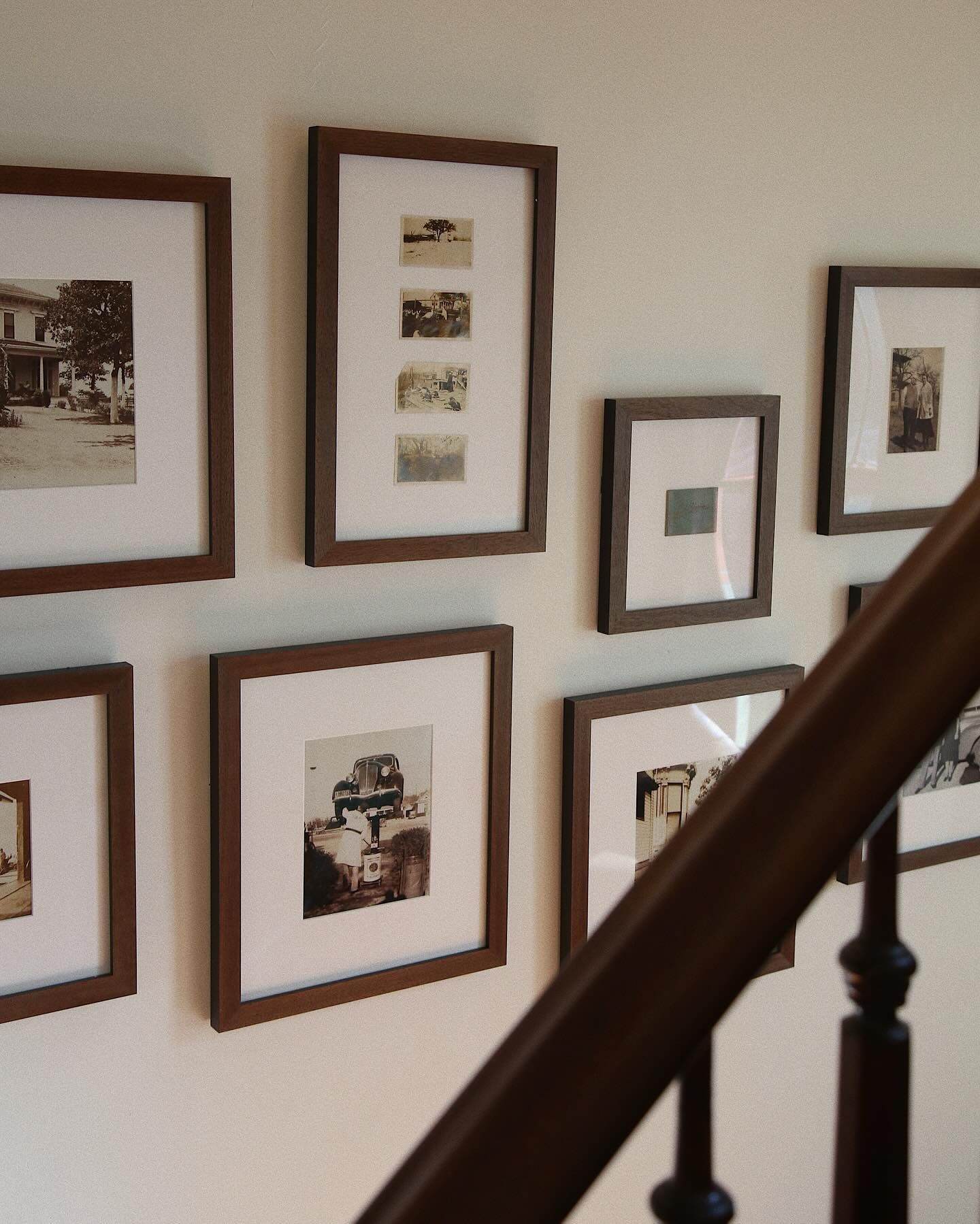 A staircase with many framed pictures on the wall