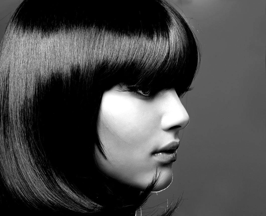 A black and white photo of a woman with long black hair and bangs.