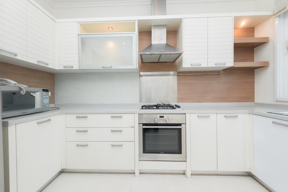 A Kitchen With White Cabinets and Stainless Steel Appliances — A1 Maintenance and Building In Old Bar, NSW