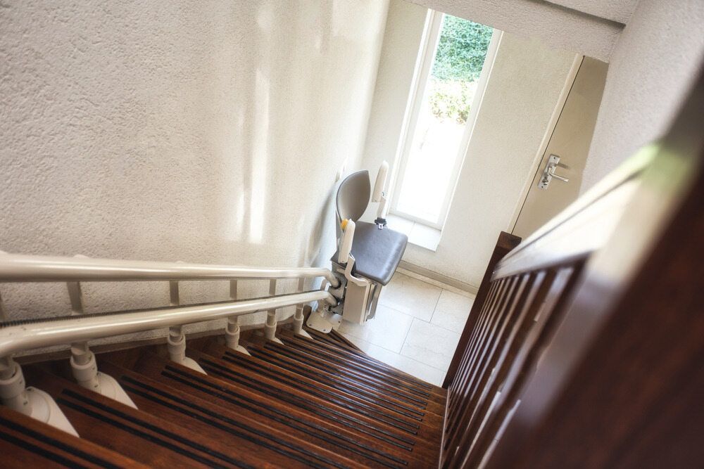 Wooden Staircase With White Railing and Wall-mounted Stairlift — A1 Maintenance and Building In Old Bar, NSW
