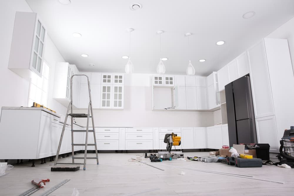 A Kitchen is Being Remodelled With White Cabinets and Black Appliances — A1 Maintenance and Building In Old Bar, NSW