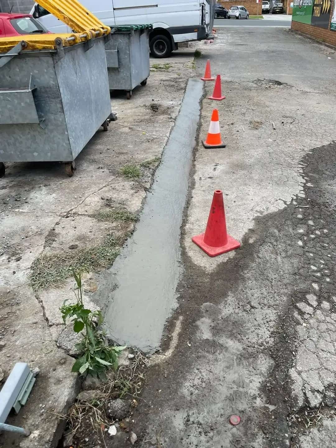 A Row of Orange and White Traffic Cones Are Sitting on the Side of a Road — A1 Maintenance and Building In Old Bar, NSW