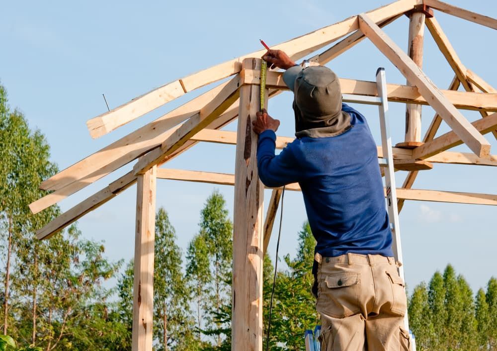 A Carpenter Working on the Frame of a Structure Outdoors — A1 Maintenance and Building In Old Bar, NSW