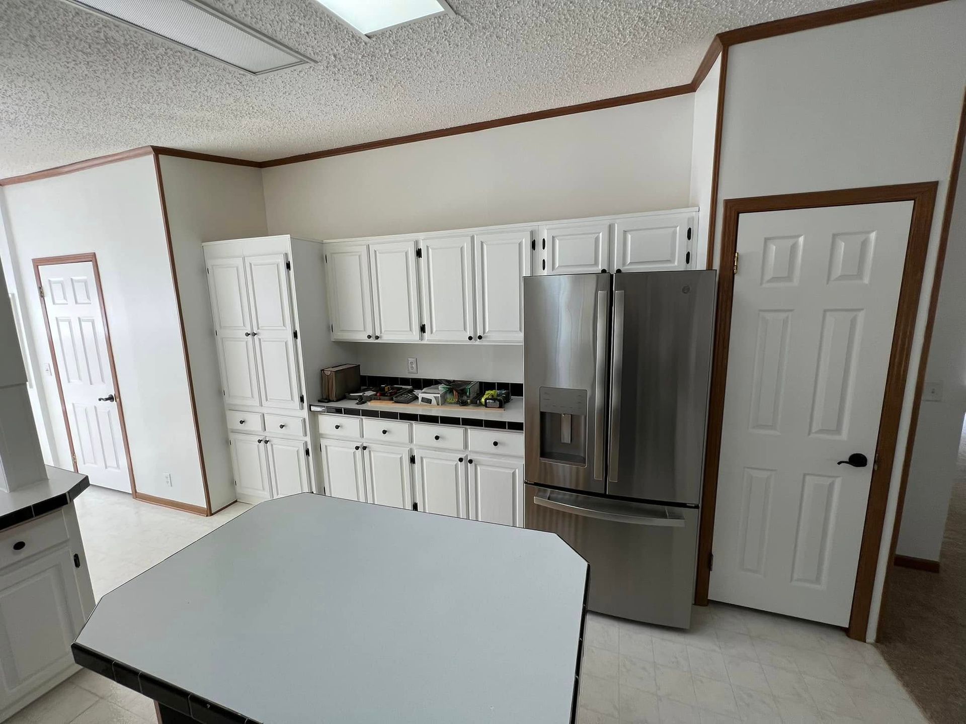 A kitchen with stainless steel appliances and white cabinets.