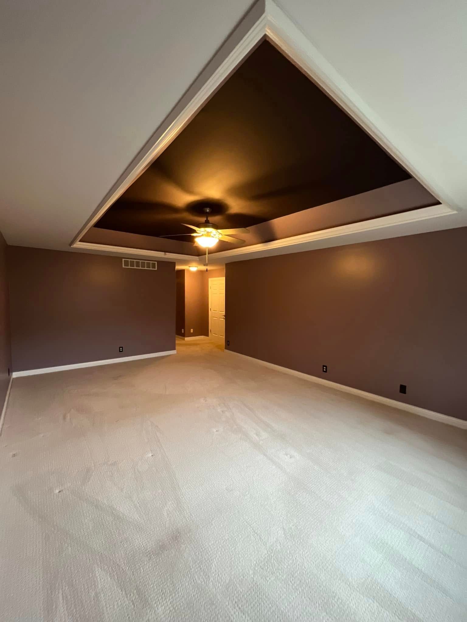 There is a ceiling fan in the middle of the room.