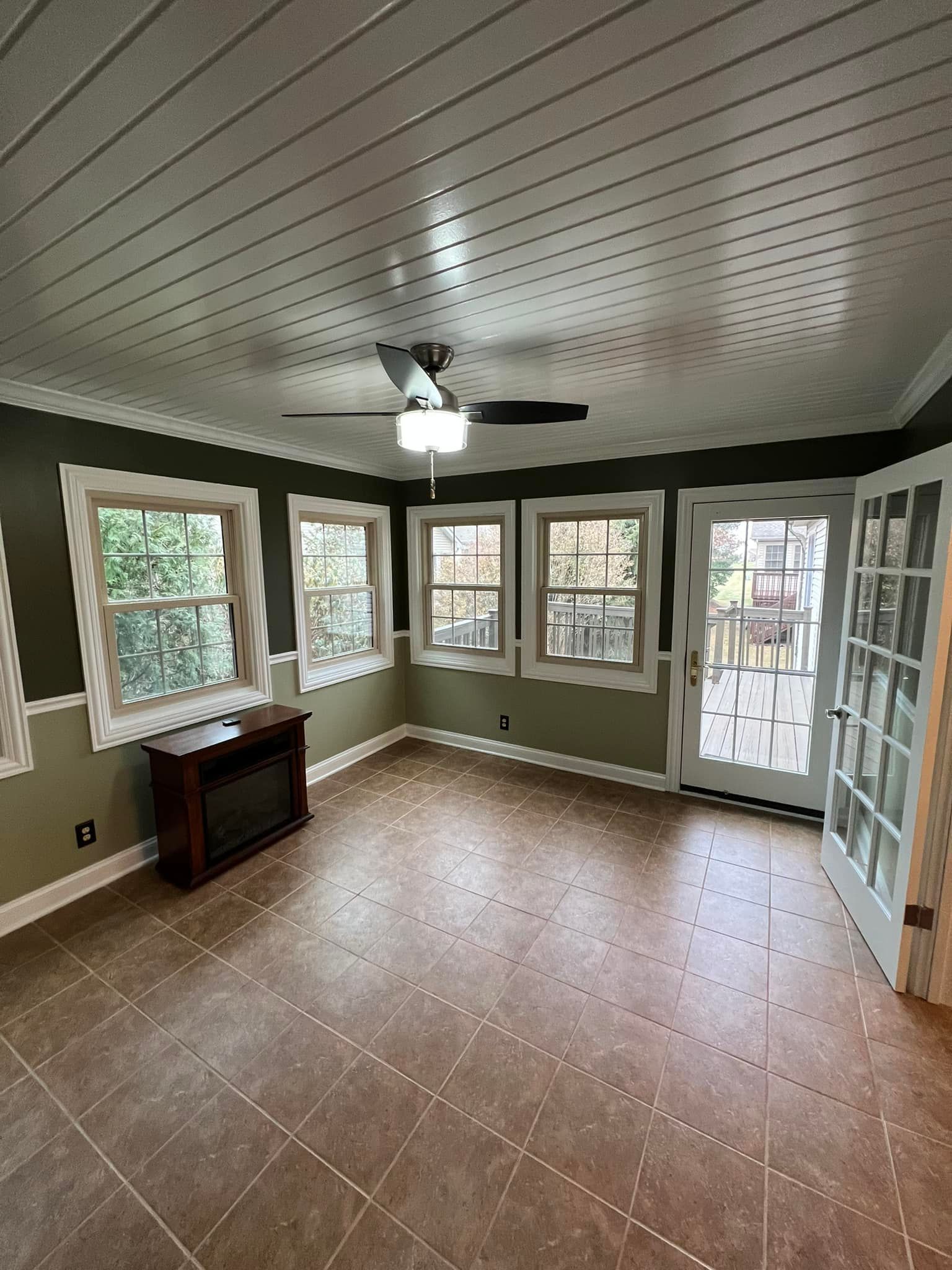 An empty living room with a ceiling fan and a fireplace.