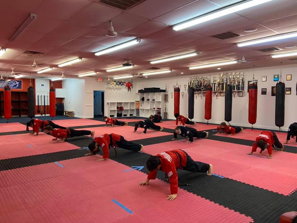 a group of people are doing push ups in a gym .