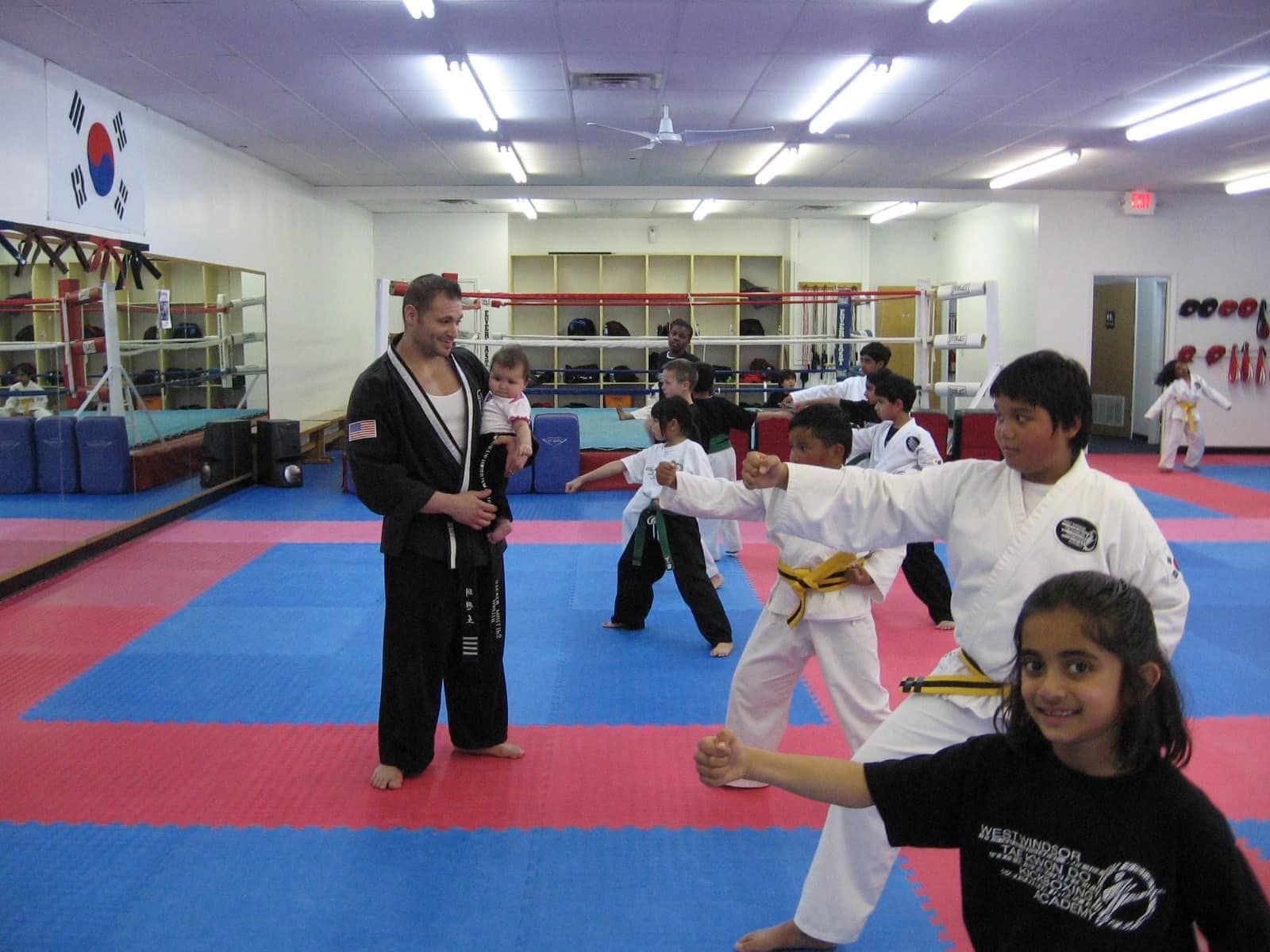 a group of kids are practicing martial arts in a gym