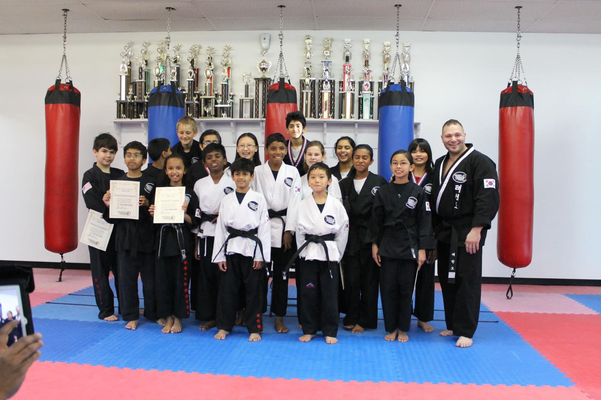a group of kids are posing for a picture in a martial arts gym .