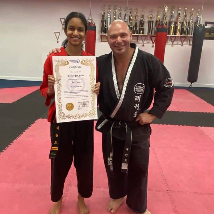 a man and a woman standing next to each other holding a certificate