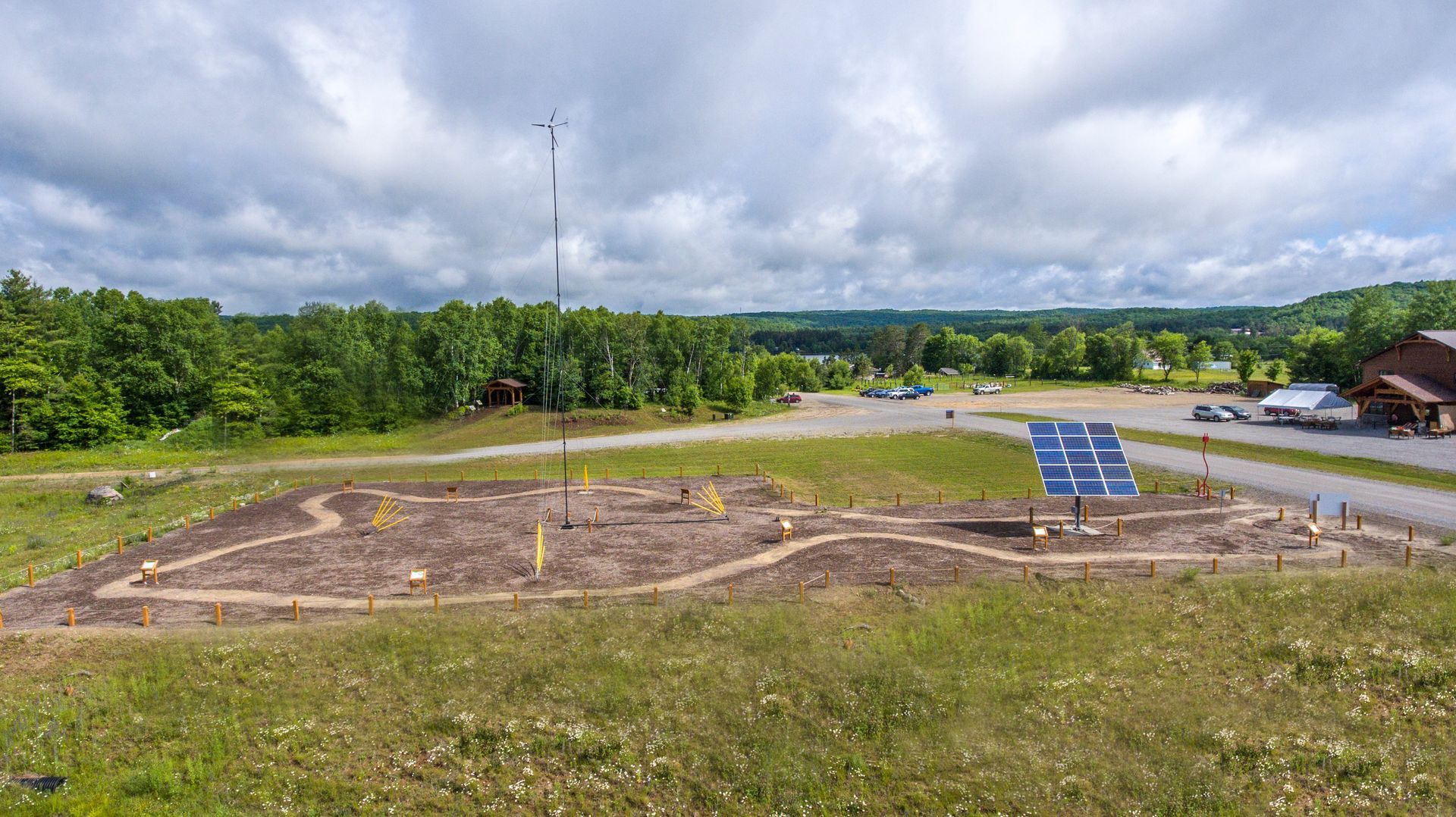 A solar panel is sitting in the middle of a grassy field.