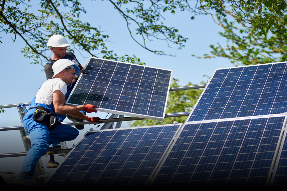Two men are installing solar panels on a roof.