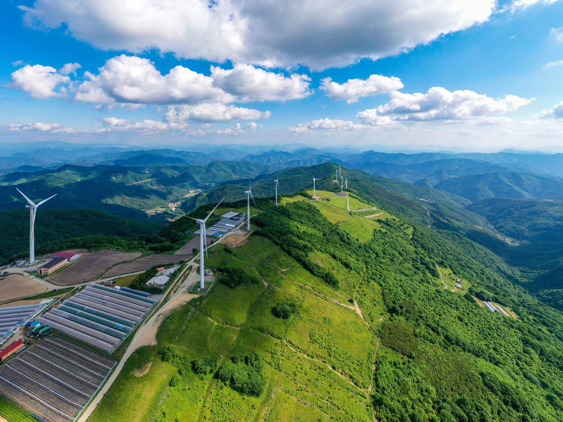 An aerial view of a wind farm on top of a mountain.
