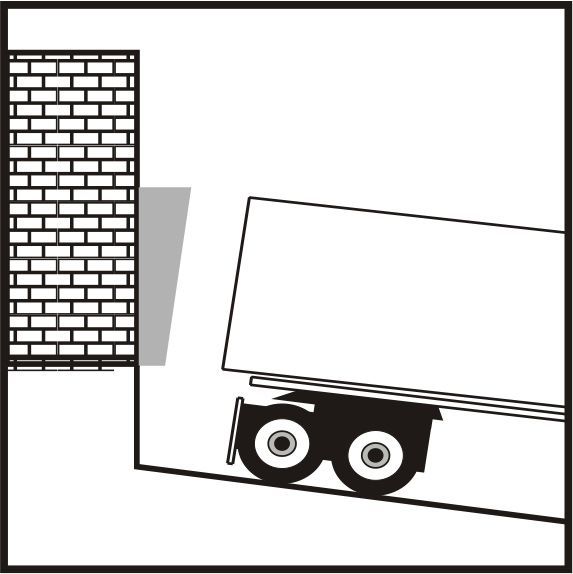 Un camion descend une colline à côté d'un mur de briques.