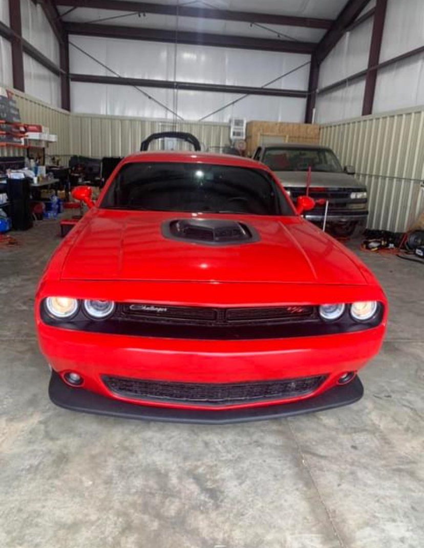 Red Dodge Challenger car inside a garage.