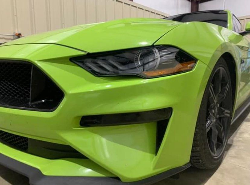 Green Ford Mustang sports car with black accents.
