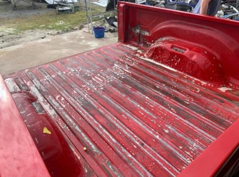 Red truck bed with white residue on the floor and sides.