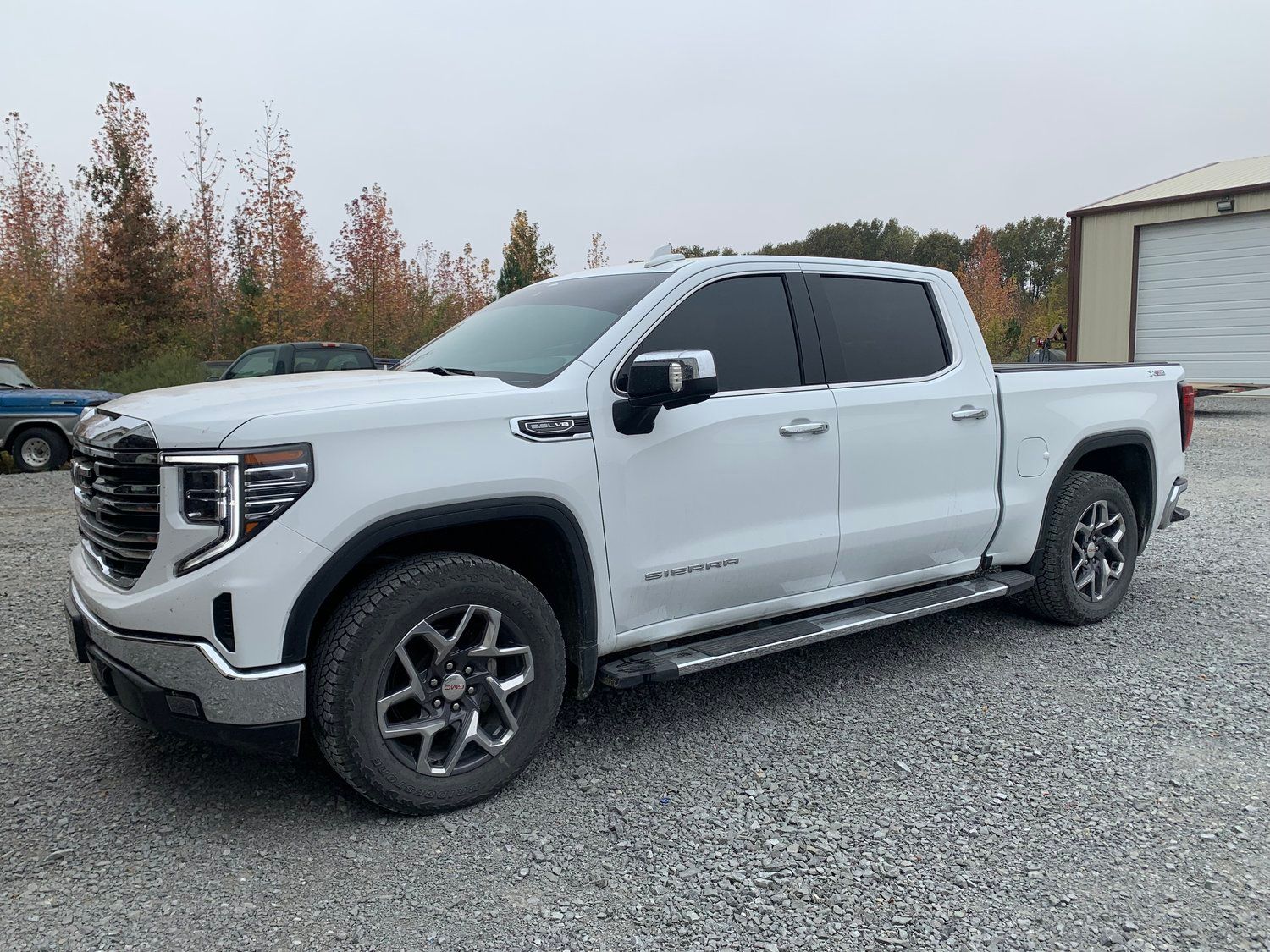 White GMC Sierra pickup truck parked on gravel.