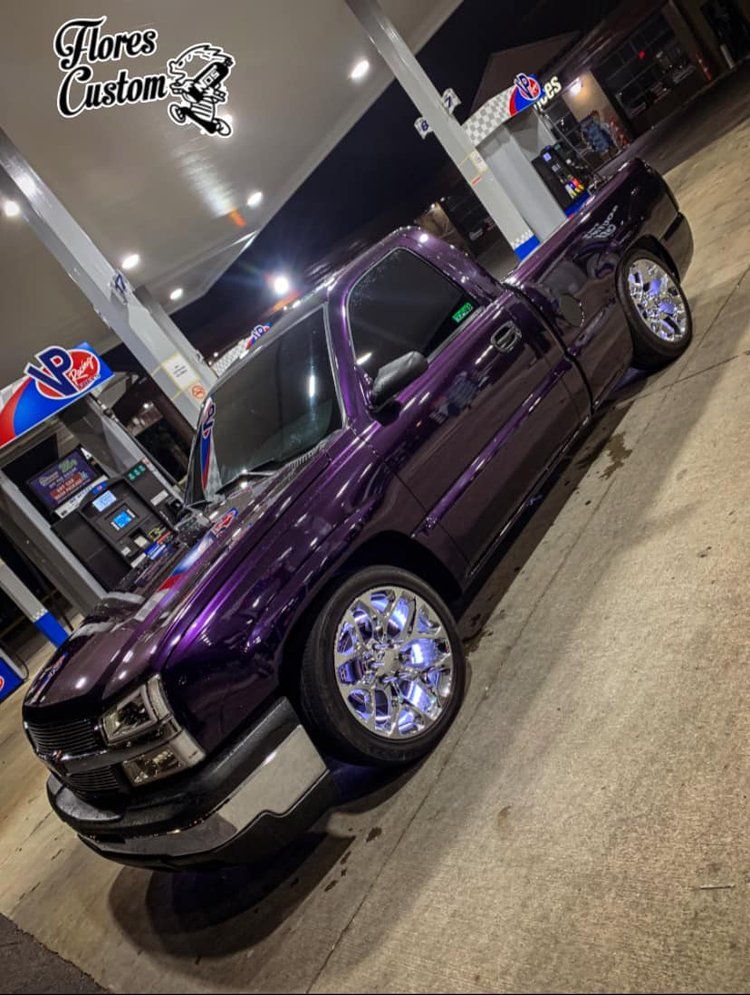Purple customized truck at a gas station with chrome rims and Flores Custom logo.