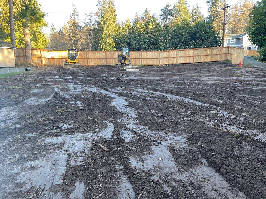 A large dirt field with a wooden fence in the background.