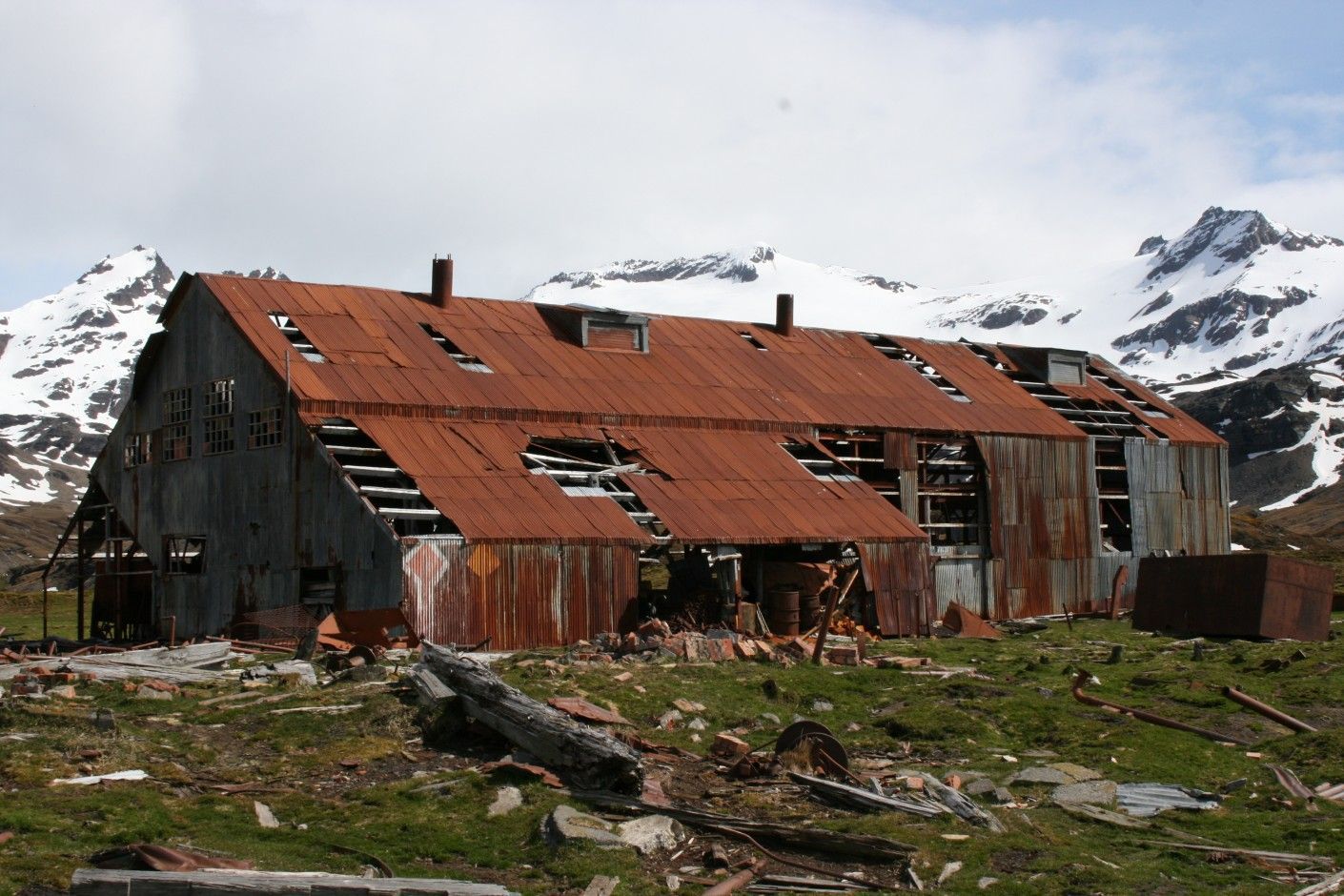 An old rusty building in South Georgia with a mountain in the background