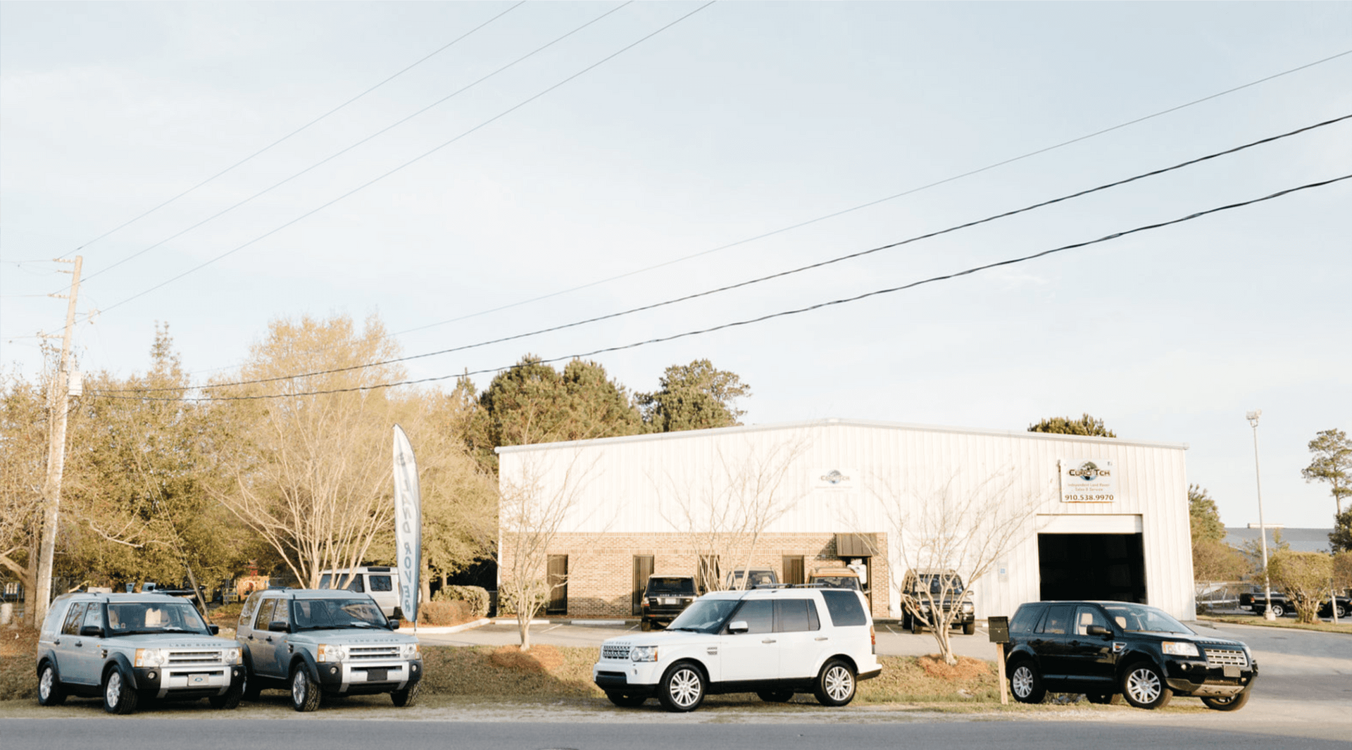 A row of cars are parked in front of a building.