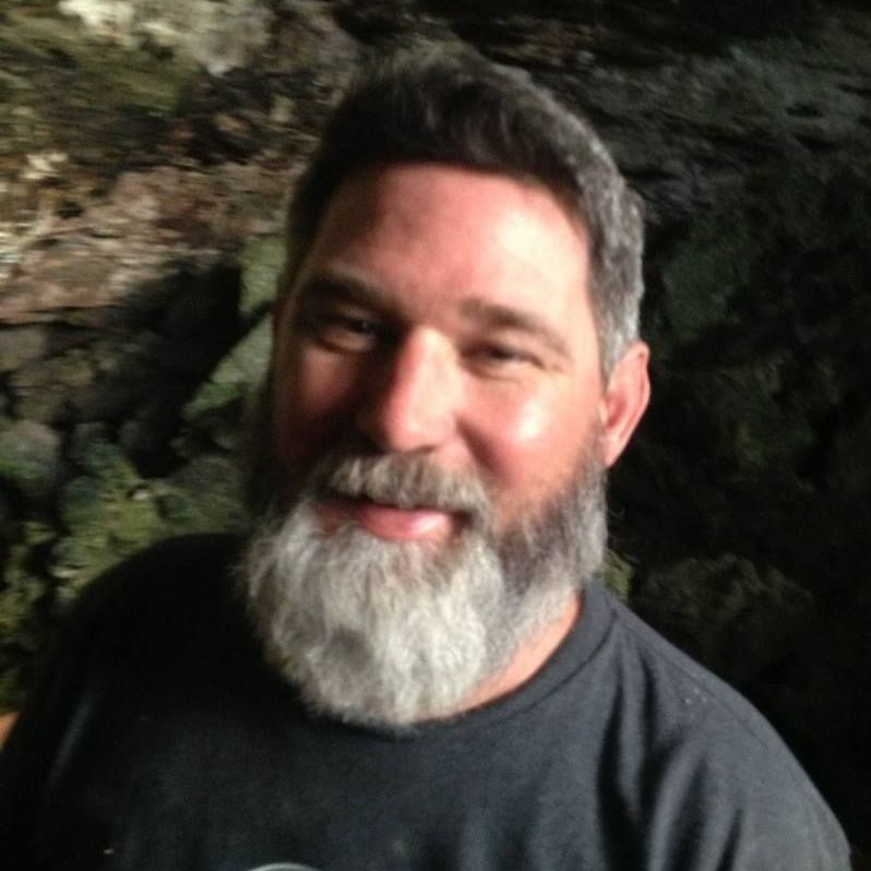 A man with a beard is wearing a black shirt