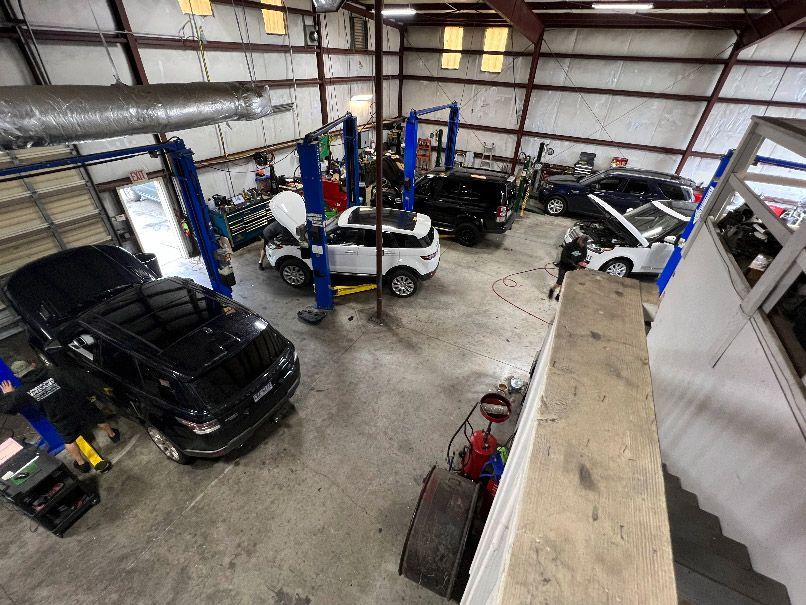 Auto repair shop with several cars on lifts and the floor in New Hanover County, NC