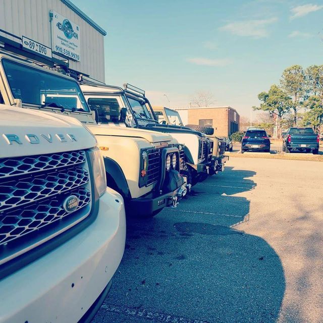 A row of rover cars are parked in front of a building