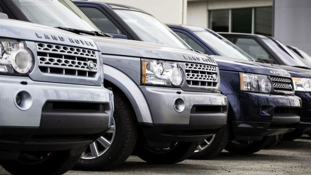 A green land rover is on a lift in a garage