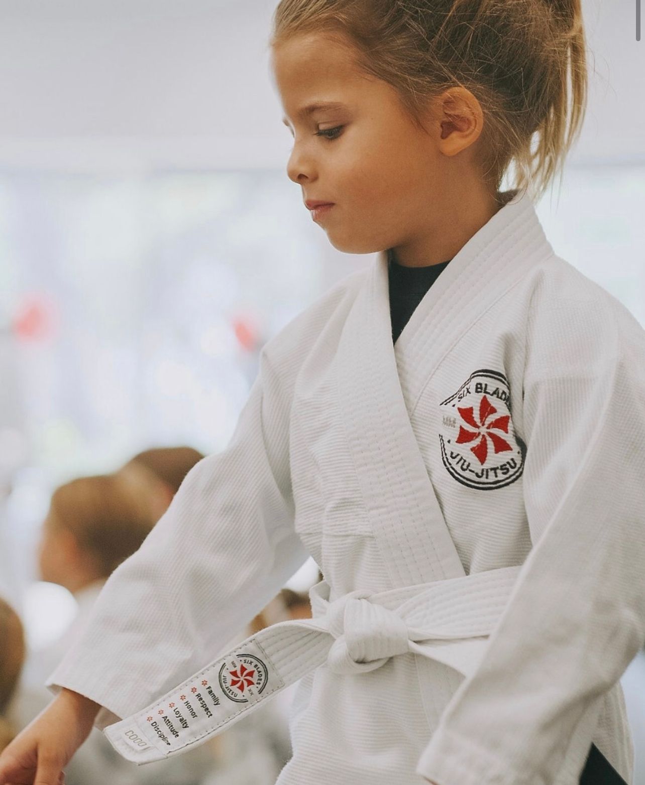 Five men in black gi uniforms, with belts, posing.
