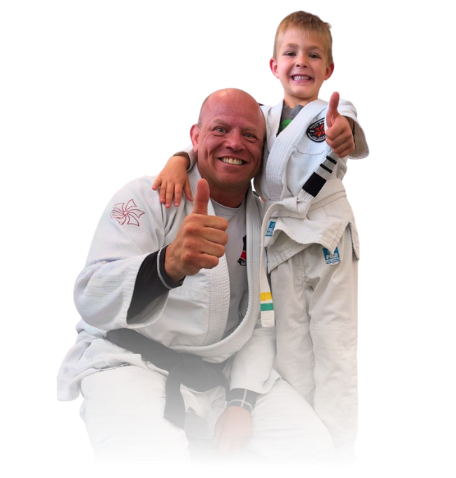 Man pointing, smiling, wearing black hoodie; arm tattoo visible.