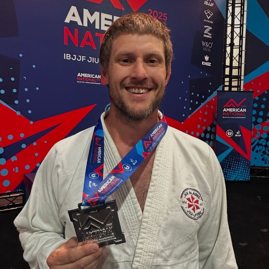 Four men in athletic gear, posing for a photo in a gym.