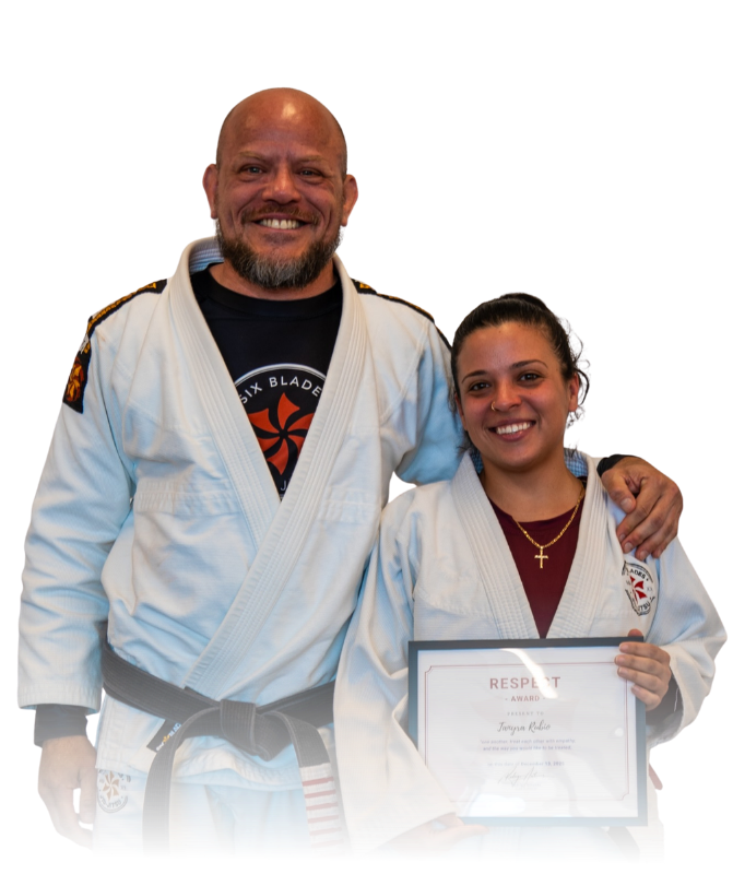 Man pointing, smiling, wearing black hoodie; arm tattoo visible.