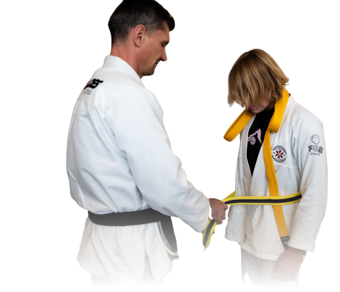 Man pointing, smiling, wearing black hoodie; arm tattoo visible.