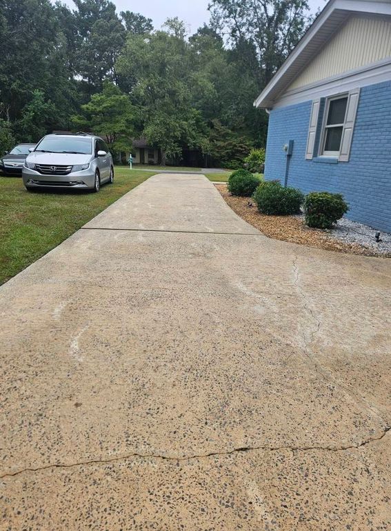 Man pressure washing a red tile roof.