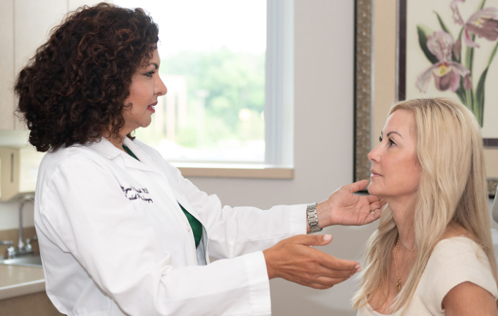 Woman in white athletic wear poses with hand on hip. Woman in white athletic wear poses with hand on hip.