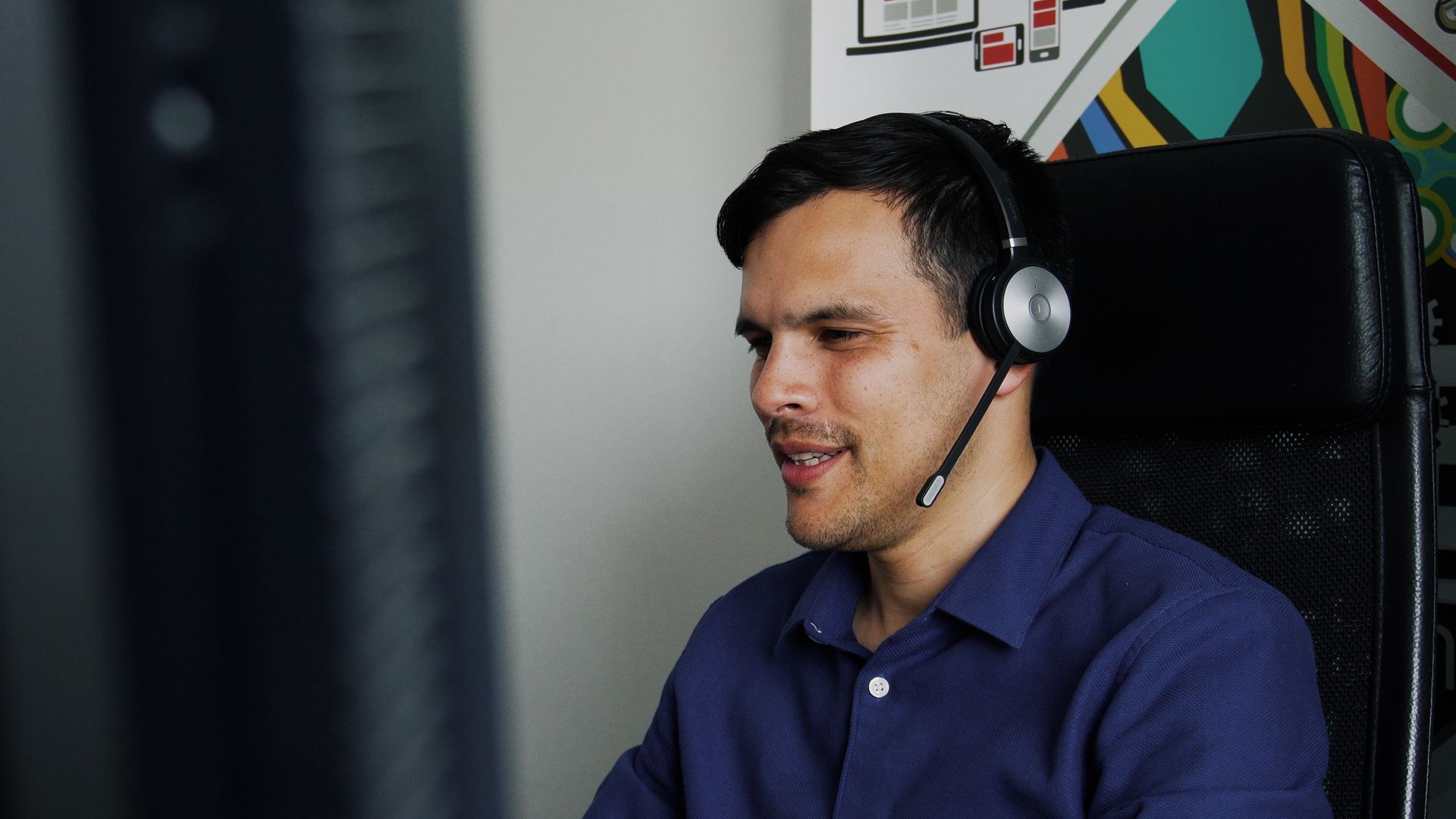 Diego, notre commercial, utilise un casque micro pour appeler nos clients, illustrant notre engagement envers le service client et la communication proactive.