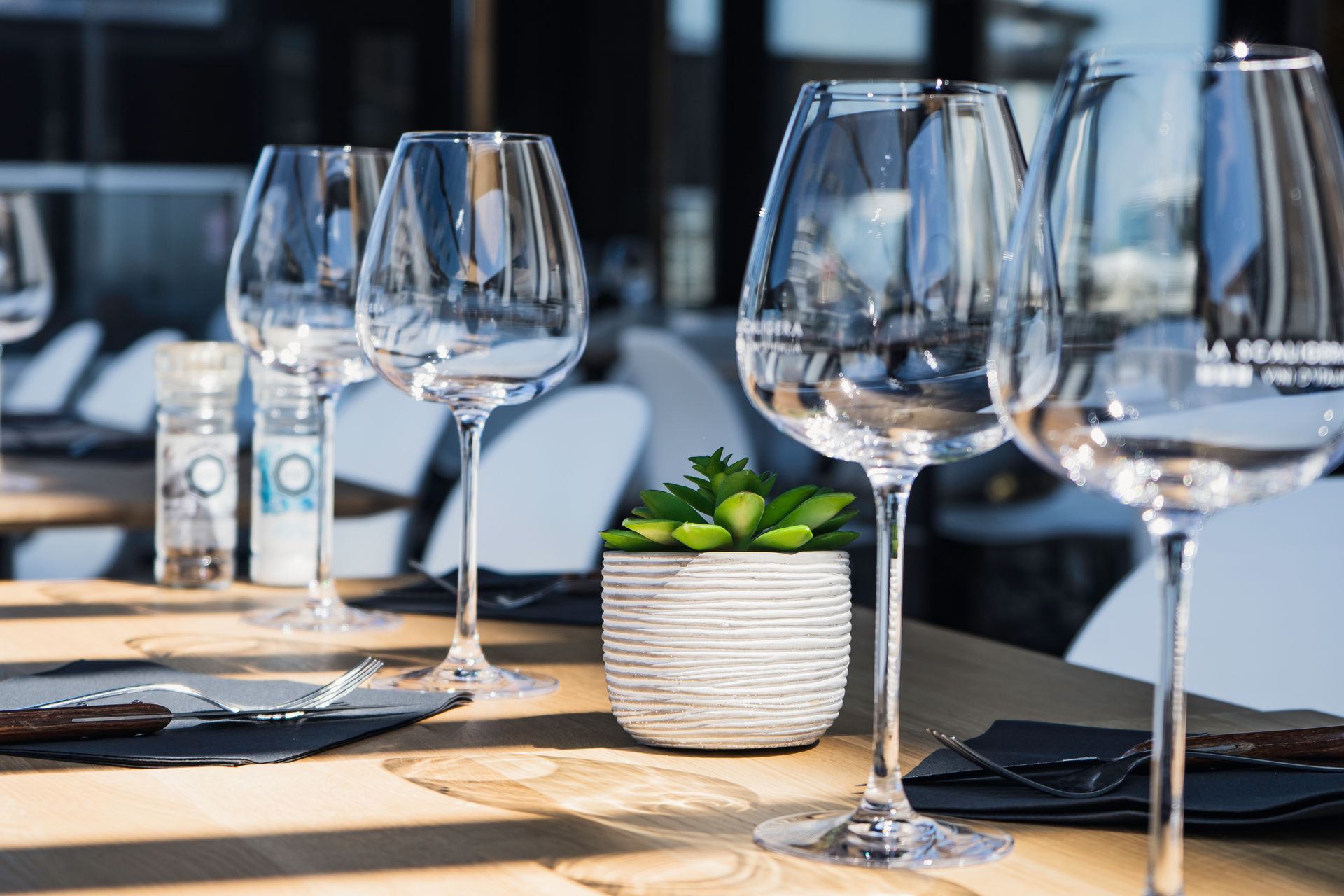 Vue rapprochée de verres de vin disposés sur les tables du restaurant La Piazzetta.